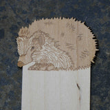 Close up of wooden bookmark with a hedgehog design