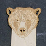 close up of a wooden bookmark with a bear head design