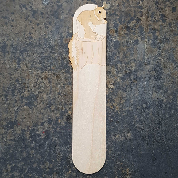 Squirrel wooden bookmark featuring a squirrel eating nuts on a tree stump