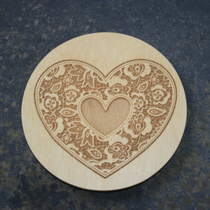 Wooden coaster with a lace heart design
