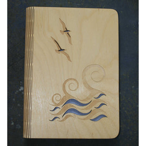 wooden note book cover with a wave and gulls seaside design