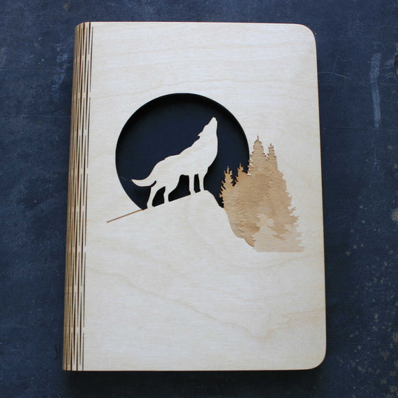 wooden note book cover with a wolf howling at the moon design