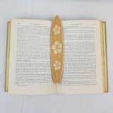 flower surfboard bookmark shown being used in a book