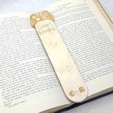 Games master wooden bookmark shown being used in a book