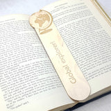 Global explorer wooden bookmark shown being used in a book