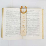 horseshoe bookmark shown being used in a book