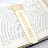 telly addict wooden bookmark shown being used in a book